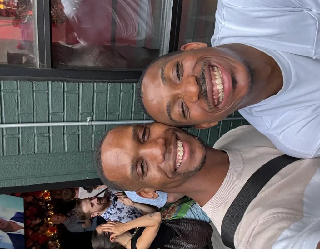 Lapo and a friend smiling in a brick wall selfie