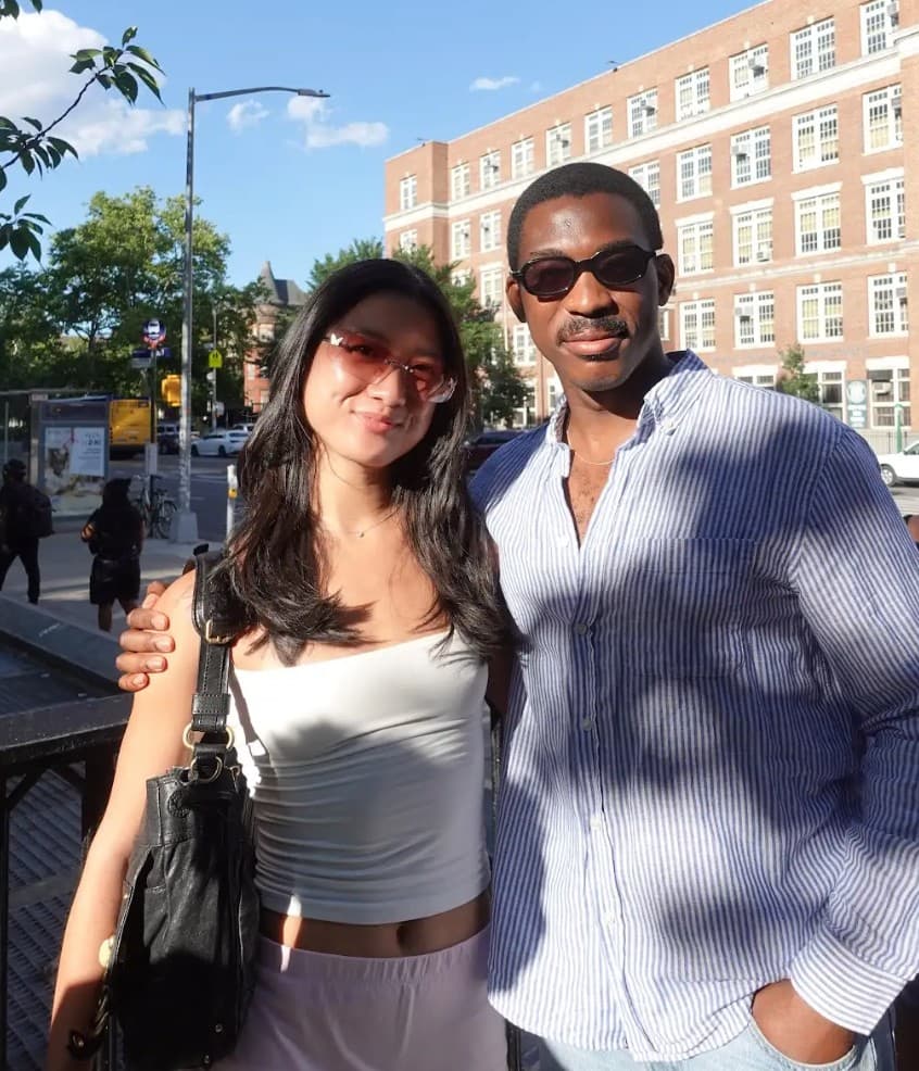 Lapo with a partner on a sunny afternoon in front of a brick building