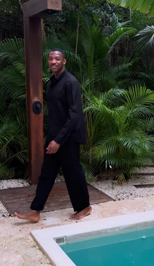 Lapo walking barefoot by a pool in tropical greenery