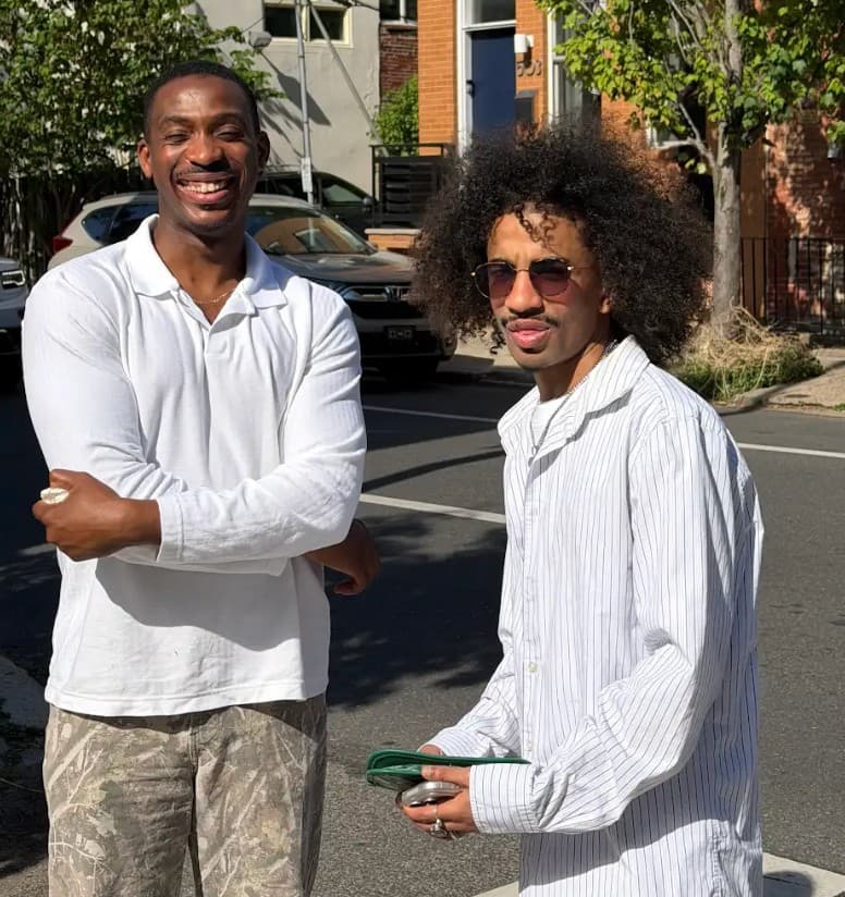 Lapo laughing with a friend on a sunny city street